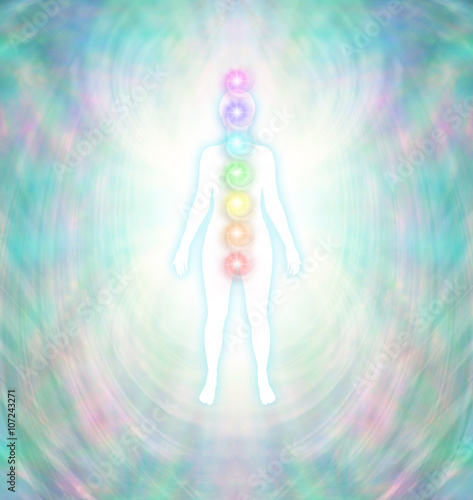 Chakra Energy Balancing  -  Soft pastel colored energy field around a white female silhouette with a turquoise glow, with seven chakras aligned centrally from crown to root photo