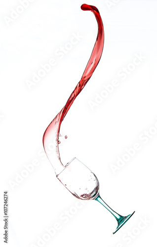 Vino rosso in movimento da bicchiere di vetro su sfondo bianco