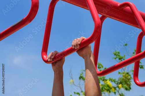 Close up of hanging boy's hands on the brachiating bar photo