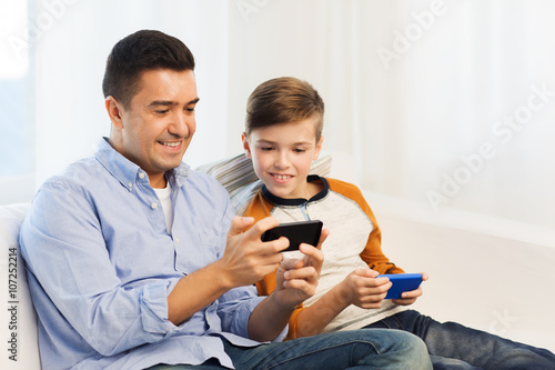 happy father and son with smartphones at home