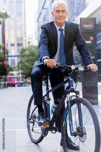 Successful businessman riding bicycle