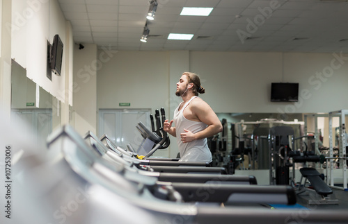 Man running in a gym on a treadmill