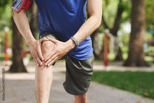 Φωτογραφία Cropped image of man rubbing his knee after jogging