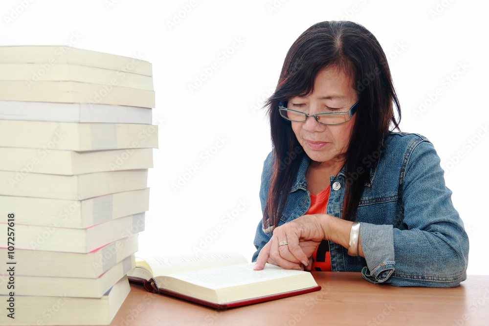 Senior asian woman reading book on white background Senior asian woman reading book on white background
