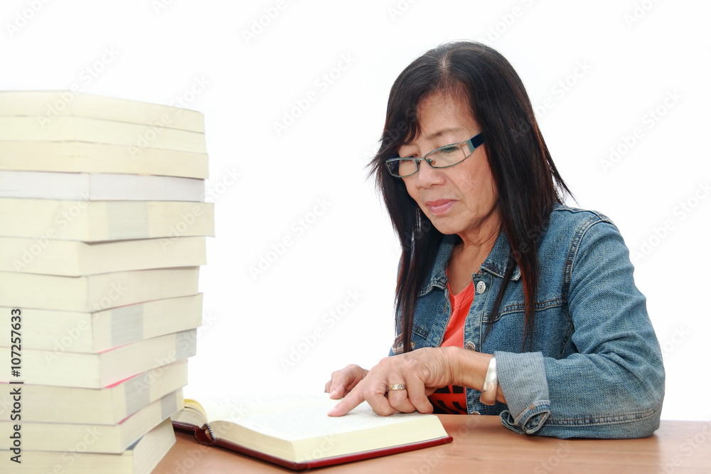 Senior asian woman reading book on white background Senior asian woman reading book on white background