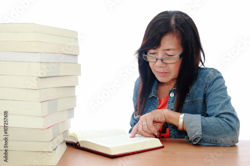 Senior asian woman reading book on white background