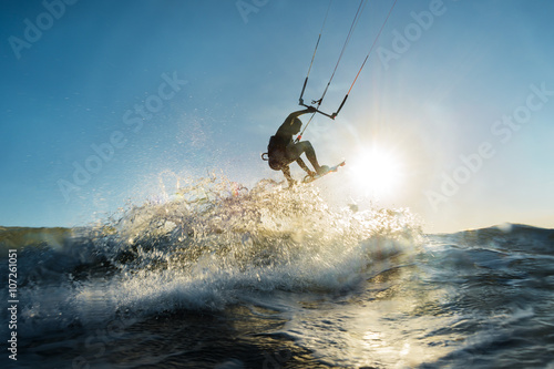 Surfer jumping at the sunset photo