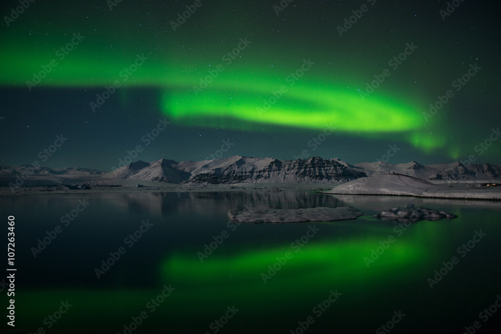 The Northern Lights dance over the glacier lagoon Jokulsarlon, Iceland