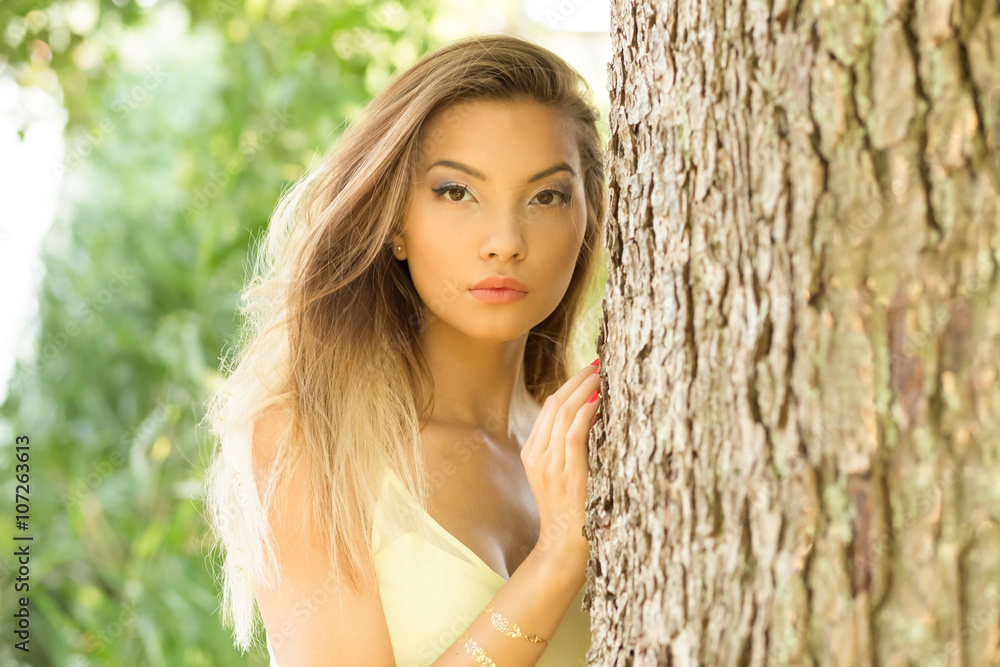Portret pięknej Azjatki przy drzewie. - obrazy, fototapety, plakaty 