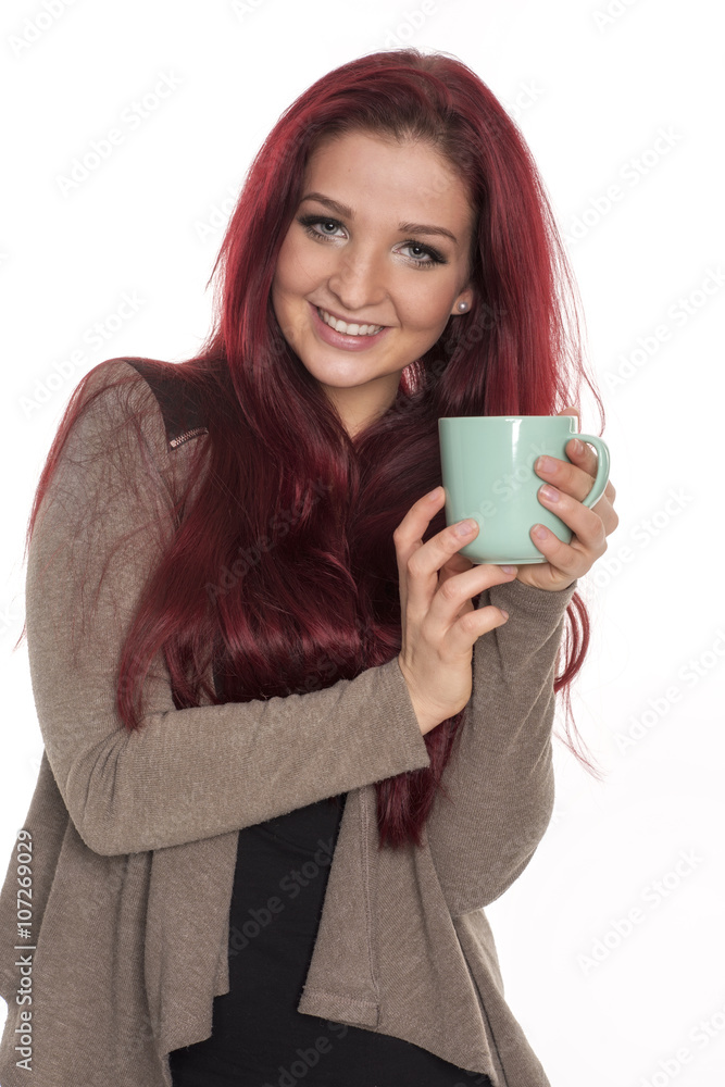 Rothaariges Mädchen hält eine Kaffeetasse und lächelt Rothaariges Mädchen hält eine Kaffeetasse und lächelt