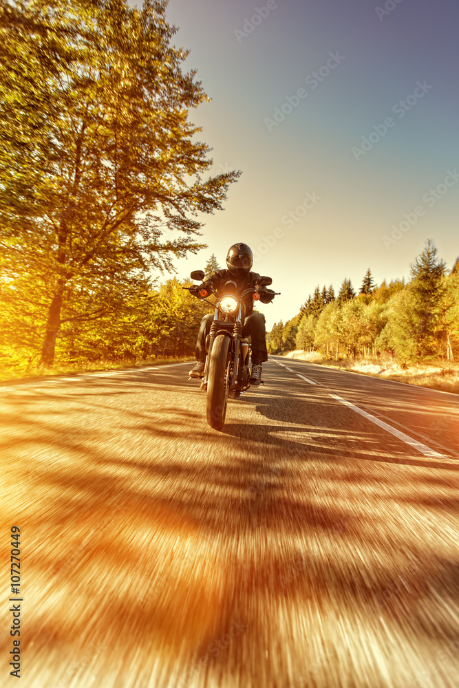 Obraz premium Man seat on the motorcycle on the forest road.