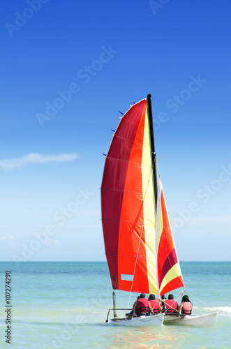 Colorful catamaran with four passengers on board heading out to