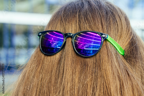 Obraz na plátně Sun glasses with color glasses on the nape of the girl