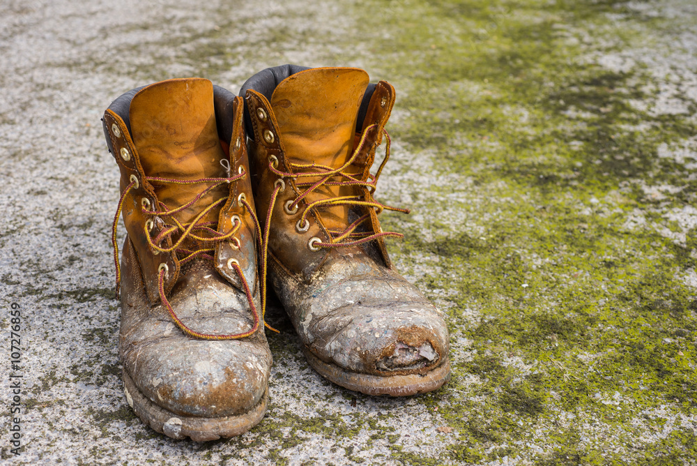 Old worn work boots on grungy dirty ground background Stock Photo ...