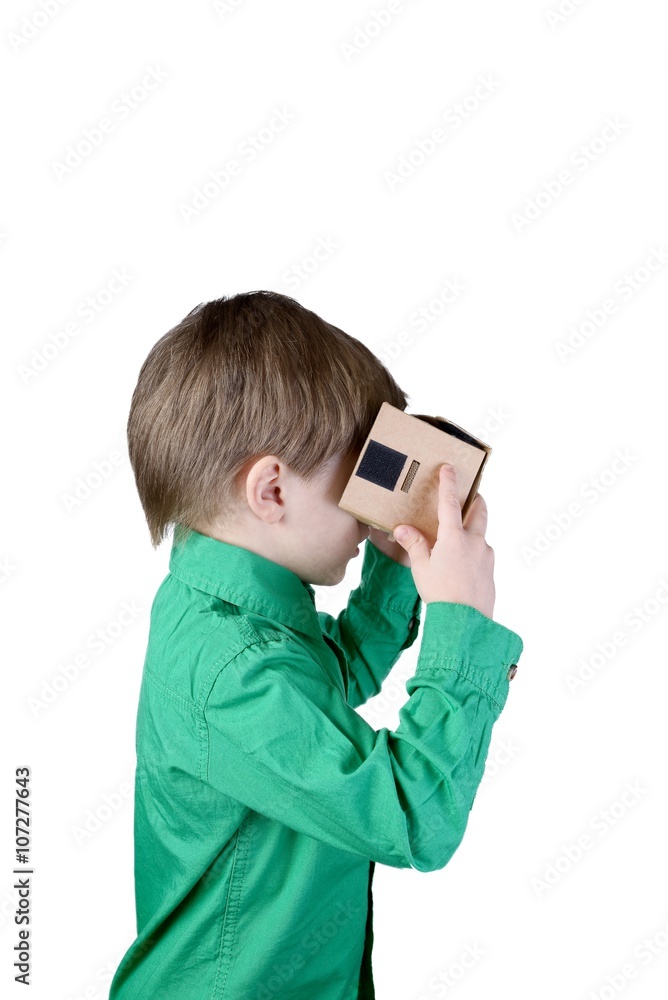 Little child uses virtual reality (VR cardboard) isolated on white background Little child uses virtual reality (VR cardboard) isolated on white background