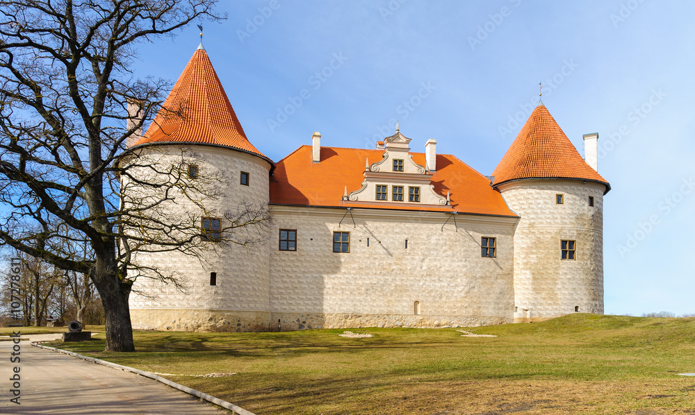 Old medieval castle with orange roof in Bauska town, Latvia