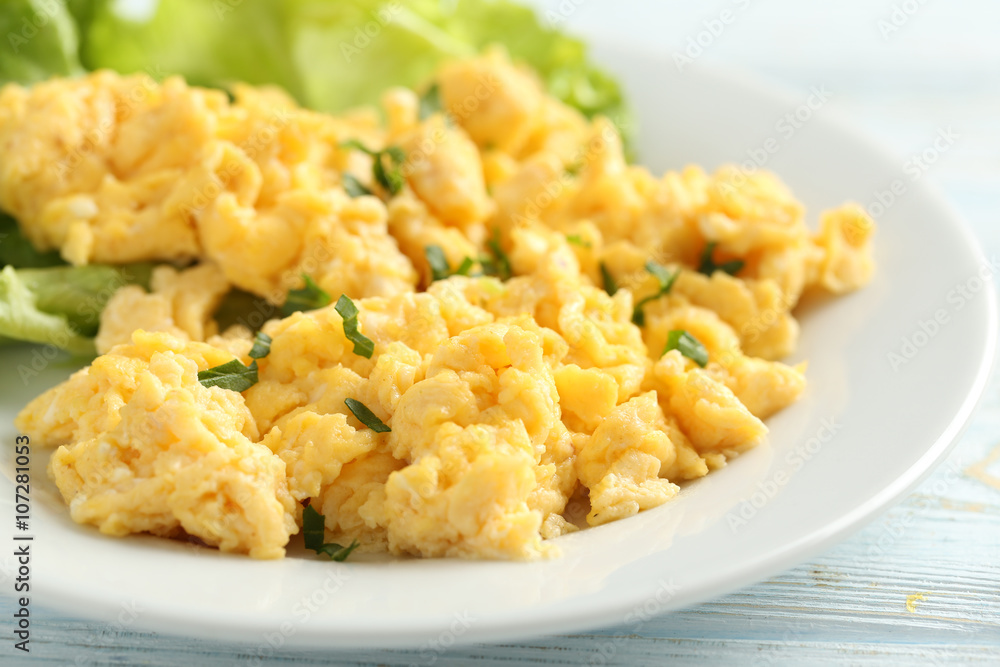 Scrambled eggs with vegetables on a blue wooden table