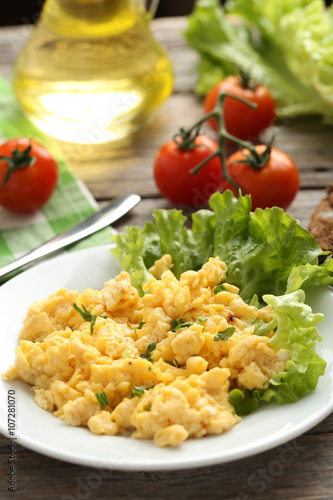 Scrambled eggs with vegetables on a grey wooden table