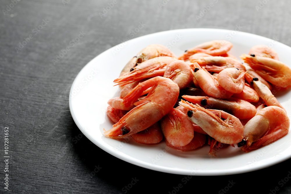 Fresh boiled shrimps on a black wooden table Fresh boiled shrimps on a black wooden table