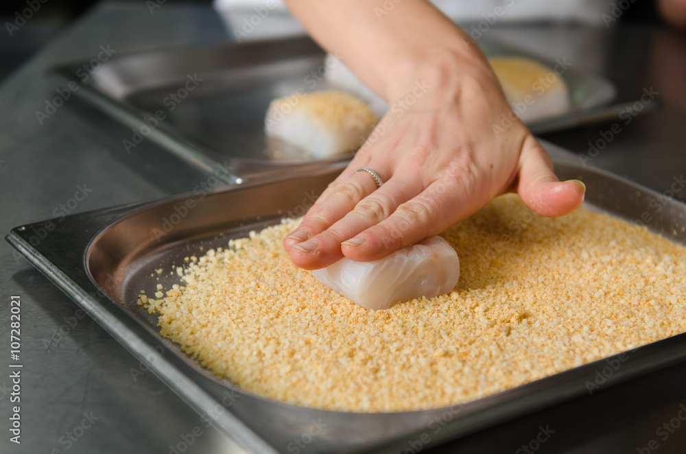 Fresh fish fillet cube being placed into breadcrumbs,before being pan fried. Fresh fish fillet cube being placed into breadcrumbs,before being pan fried.