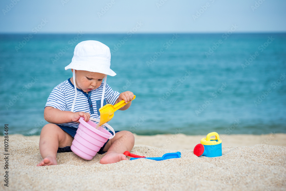 Beautiful boy playing on beach with toys Beautiful boy playing on beach with toys