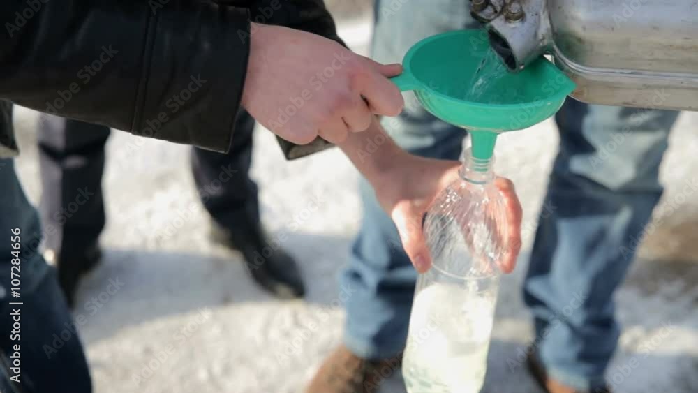 pouring gasoline from the canister in a bottle pouring gasoline from the canister in a bottle