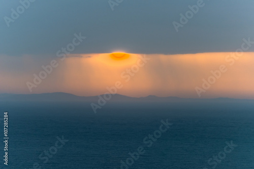 Fototapeta Naklejka Na Ścianę i Meble -  Amazing sunrise above the sea through a cloudy sky. A magnificen
