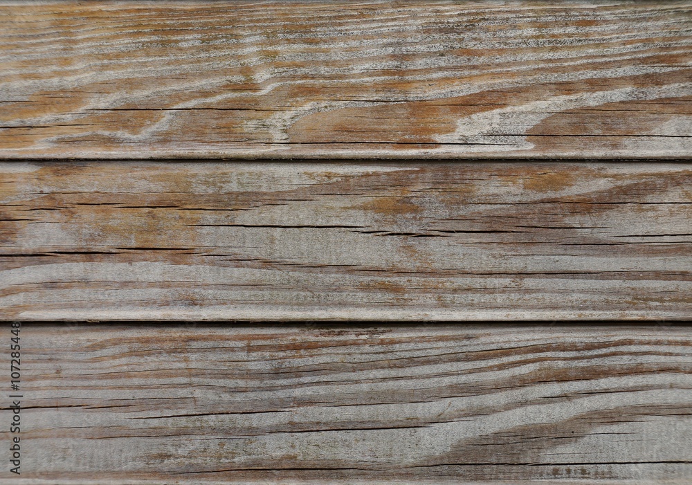 Macro of strongly weathered wood. Naturally aged by the elements. Horizontal cracks can be seen in the well dried wood. The color is partially worn away and shows the grain of the wood. Macro of strongly weathered wood. Naturally aged by the elements. Horizontal cracks can be seen in the well dried wood. The color is partially worn away and shows the grain of the wood.