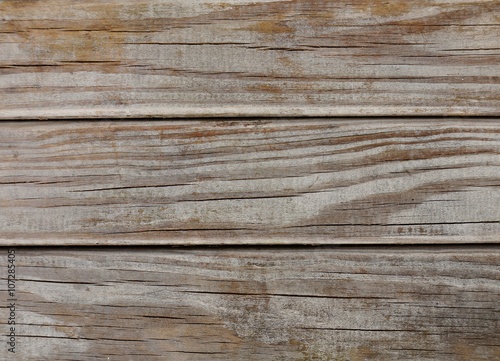 Macro of strongly weathered wood. Naturally aged by the elements. Horizontal cracks can be seen in the well dried wood. The color is partially worn away and shows the grain of the wood.