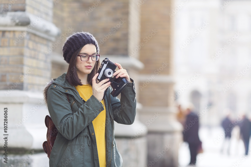 Young hipster woman takeing a pictures on vacation. She is carrying a backpack. Young hipster woman takeing a pictures on vacation. She is carrying a backpack.