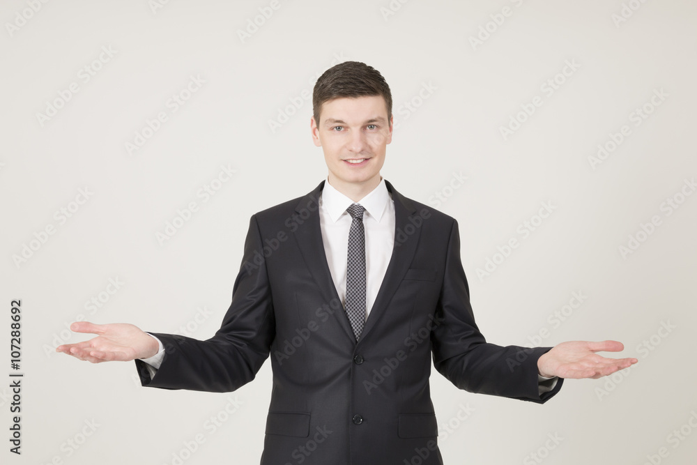Handsome young businessman with open palms Handsome young businessman with open palms
