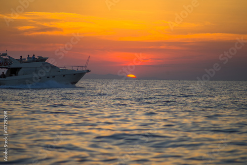 Luxurious boat sailing during sunset in Santorini, Greece. © inbulb1