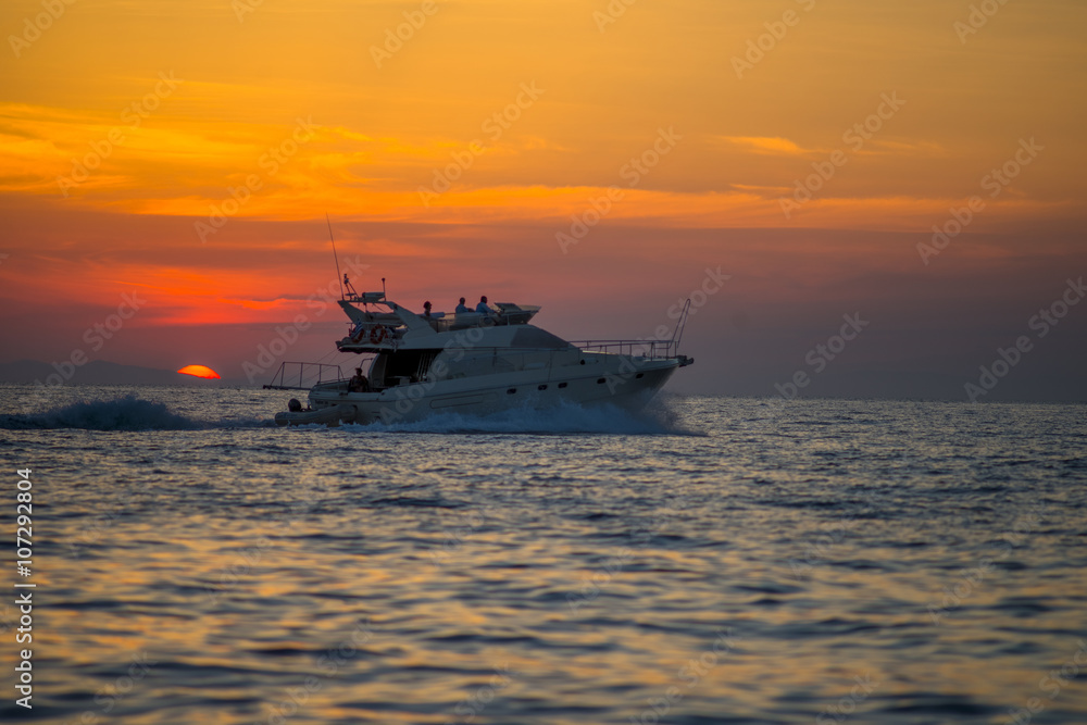 Obraz premium Luxurious boat sailing during sunset in Santorini, Greece.