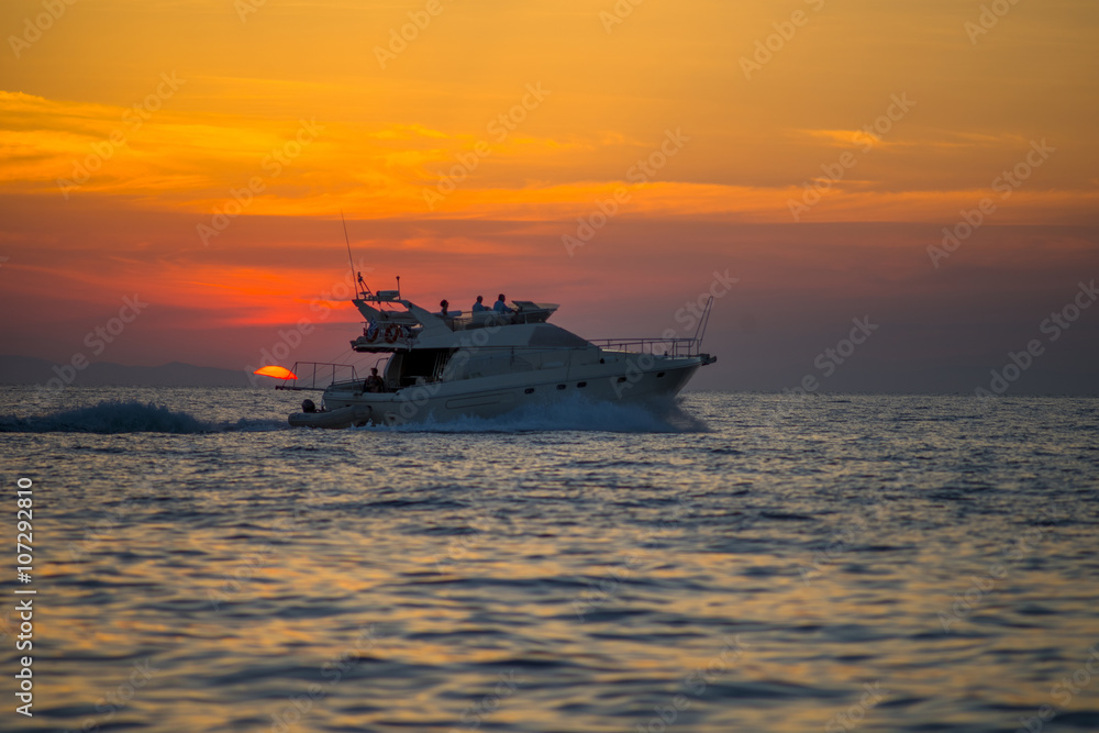 Luxurious boat sailing during sunset in Santorini, Greece. Luxurious boat sailing during sunset in Santorini, Greece.