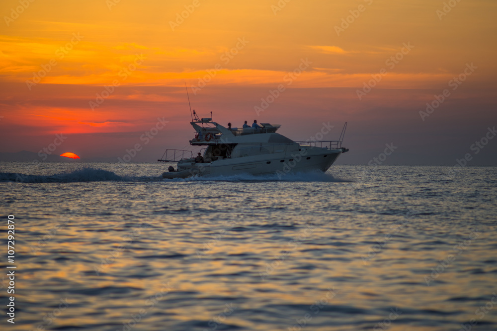 Luxurious boat sailing during sunset in Santorini, Greece. Luxurious boat sailing during sunset in Santorini, Greece.