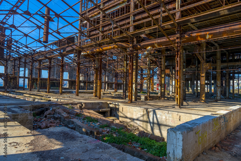 Ruins of an abandoned old factory. The remains of the steel stru Ruins of an abandoned old factory. The remains of the steel stru