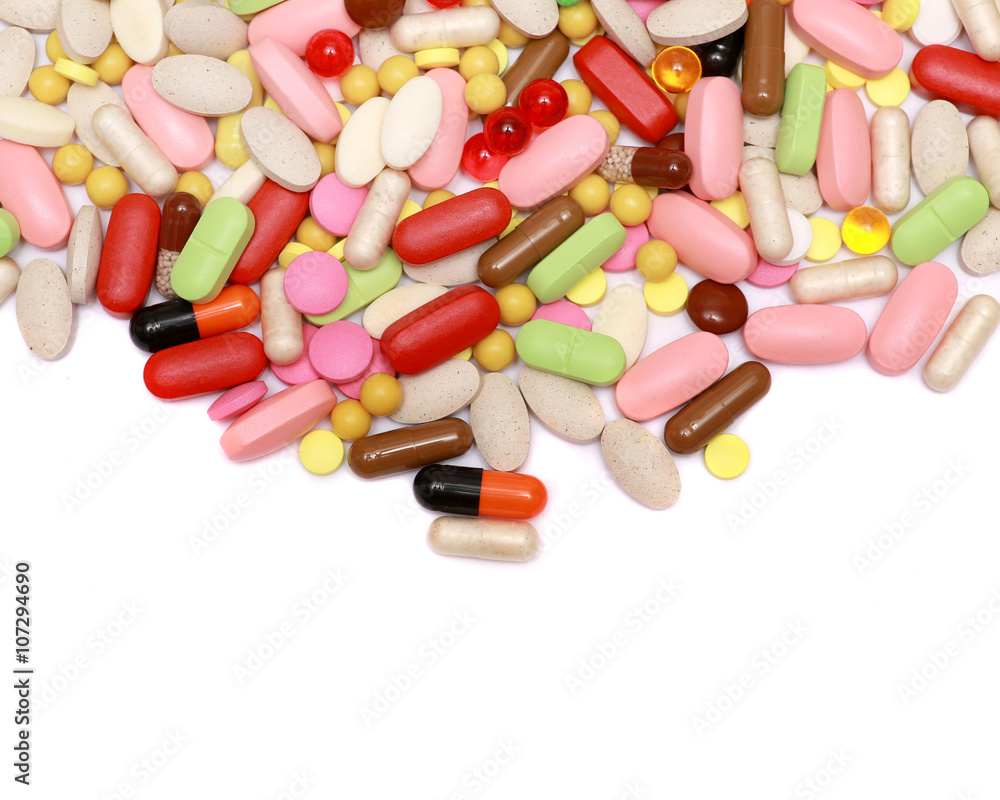 Lots of colorful tablets and pills, medical background. Macro. Isolated on white background. Lots of colorful tablets and pills, medical background. Macro. Isolated on white background.