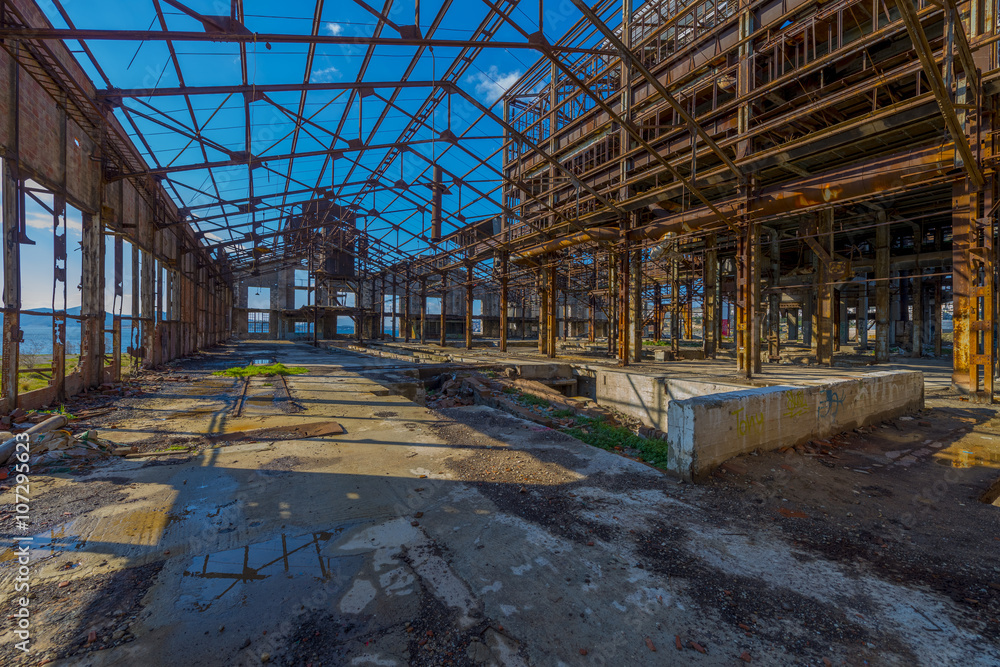 Ruins of an abandoned old factory. The remains of the steel stru Ruins of an abandoned old factory. The remains of the steel stru