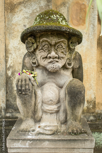 Traditional demon guard statue carved in stone on Bali island.