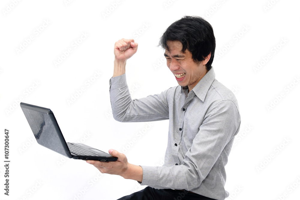 Businessman holding his fists in excitement while looking at laptop Businessman holding his fists in excitement while looking at laptop