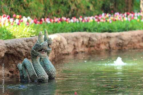 Naga statue on water and flower background