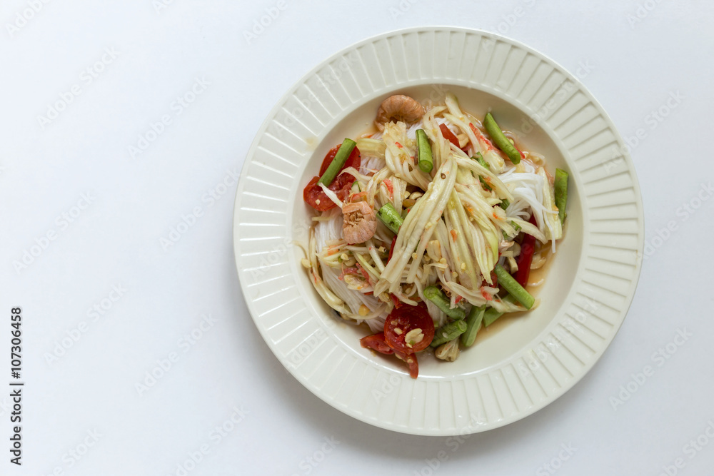 Spicy papaya salad on top of rice noodle on white background