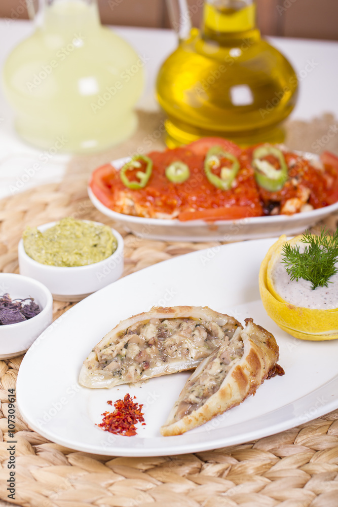 Plate of stuffed cuttlefish inside cheese, mushroom and seafood serving with aubergine salad