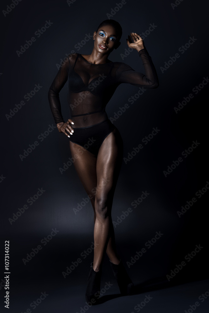 Beautiful dark-skinned young woman sensualy posing in black ling