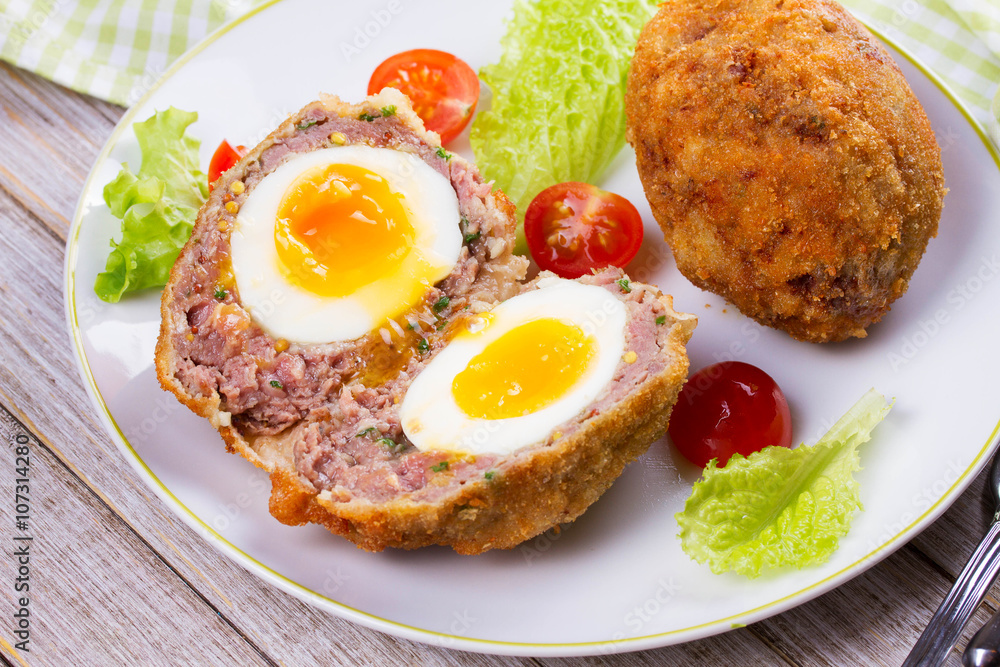Scotch Eggs Served with Tomato Cherry and Salad on White Plate Scotch Eggs Served with Tomato Cherry and Salad on White Plate