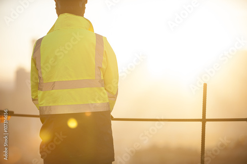 Worker at the construction site and sunrise background