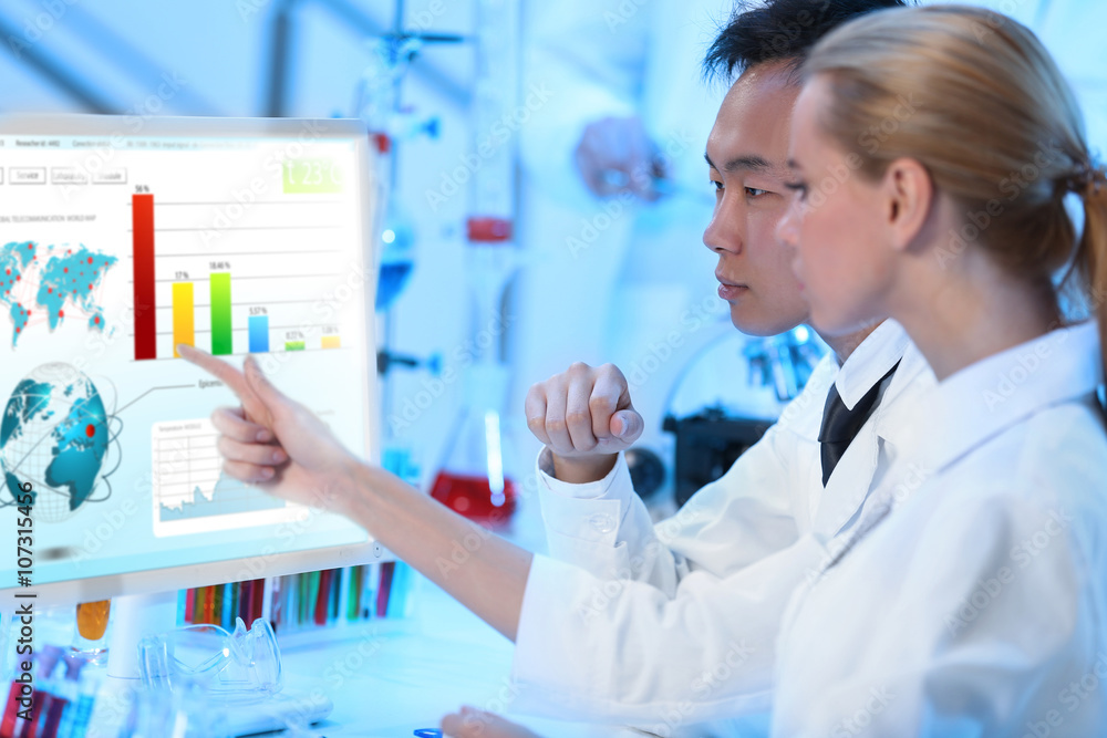 Young medical technicians working in laboratory Young medical technicians working in laboratory