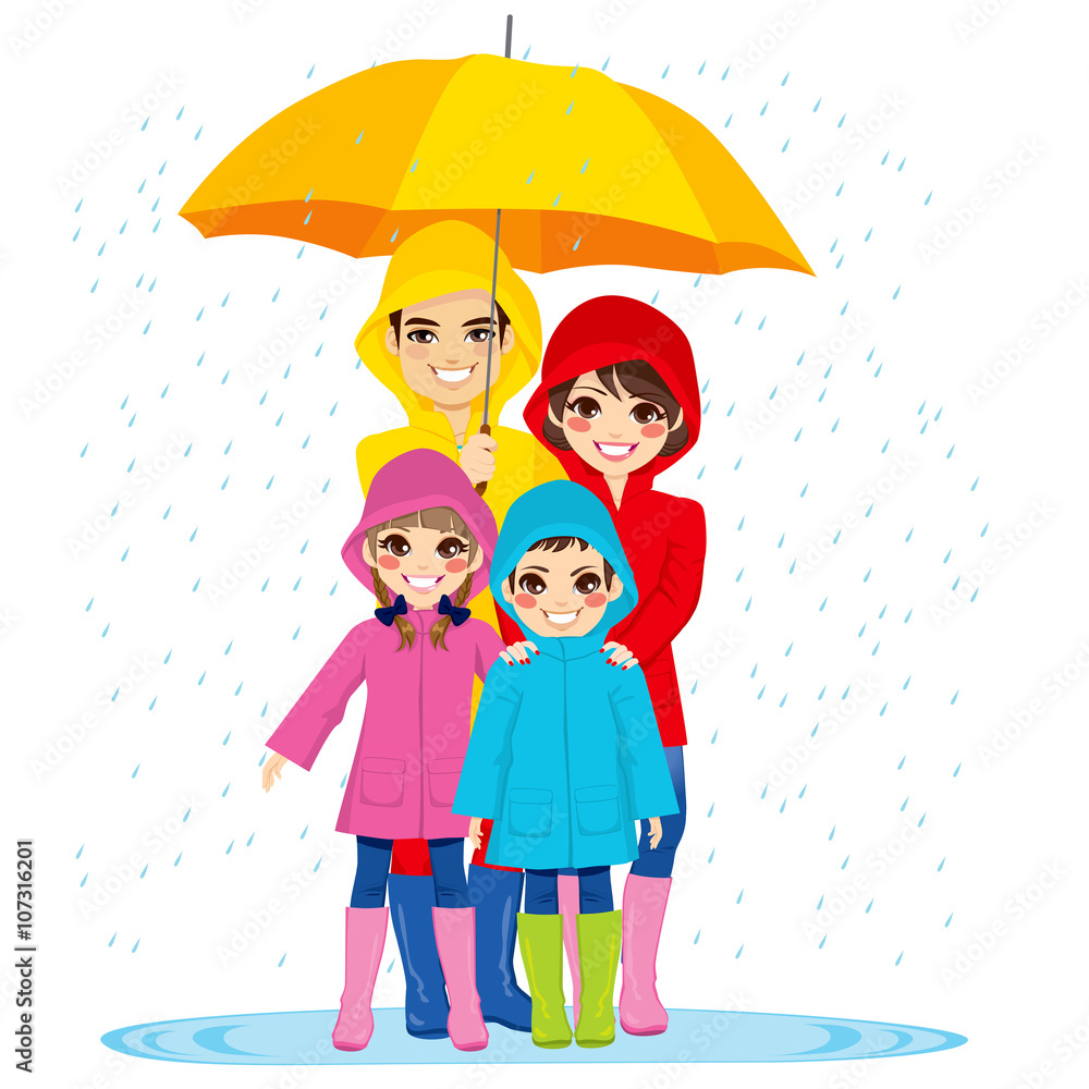 Happy family with raincoats under big umbrella on rainy day