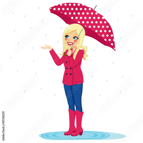 Beautiful blonde woman holding big umbrella checking if rain stops with her hand