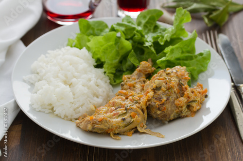 rabbit with boiled rice and lettuce on white plate